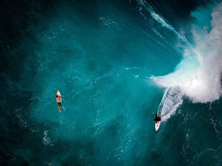2 people surfing in Hawaii from above