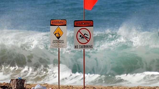 signs warning about dangerous shorebreak
