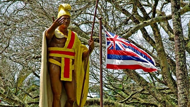 Kamehameha the great statue next to Hawaiian flag